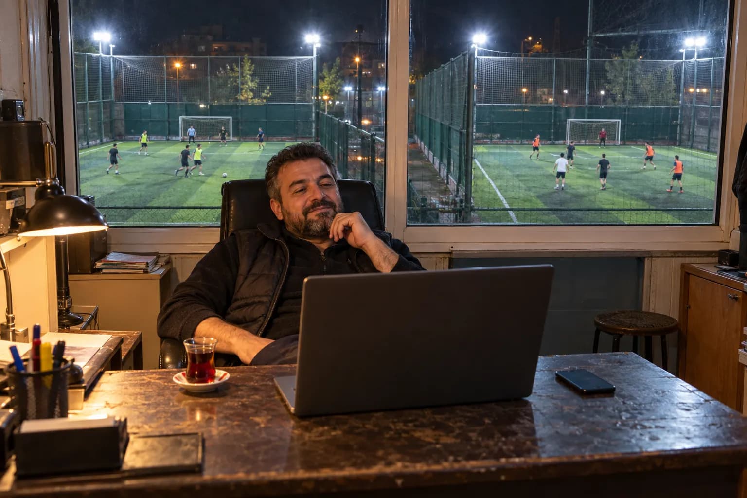 Gece ofisinde laptop başında sahaları izleyen işletmeci